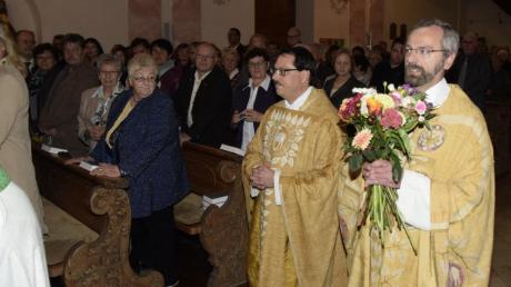 Mit einem bunten Blumenstrauß in den Händen zog Pfarrer Klaus Ammich (rechts) in die Kirche ein. 