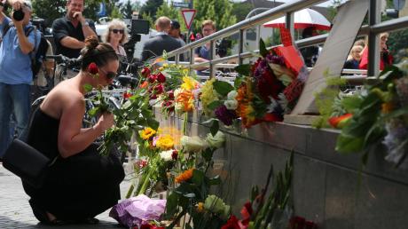 Neun Menschen kamen am Freitagabend bei der Schießerei in München ums Leben. Menschen legten am abgesperrten Zugang zur U-Bahn-Station Olympia-Einkaufszentrum Blumen für die Opfer nieder. 