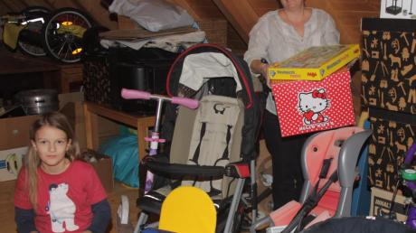 Auf dem Dachboden von Birga Wendt (mit Tochter Rika) in Roggden stapeln sich Kinderkleidung, Kinderwagen und Autositze, die im Tauschkreis die Runde machen.