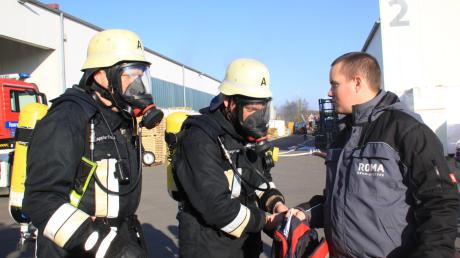 Die Atemschutz-Träger der Feuerwehr Unterthürheim holen die Utensilien der Roma-Mitarbeiter aus der verqualmten Halle.