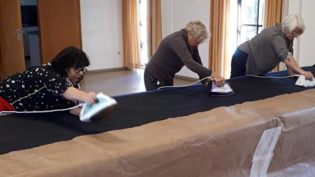 Verena Bürkner, Ricarda Straßer und Irmgard Berger (von links) bei der Restauration des brüchigen Papiers der Entwurfszeichnung.  	
