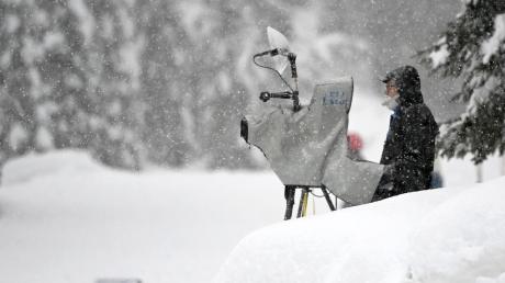 Ein TV-Kameramann steht im Schnee und filmt Wintersport.