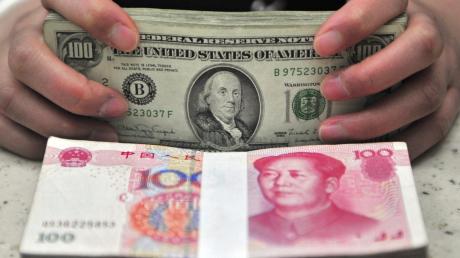 Amerikanische Dollarnoten und chinesischer Renminbi.  	