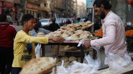 Ein Junge kauft Brot auf einem Markt in Kairo, Ägypten.