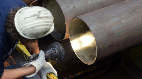 Ein Arbeiter kontrolliert in der Produktion von Vallourec Stahlrohre.