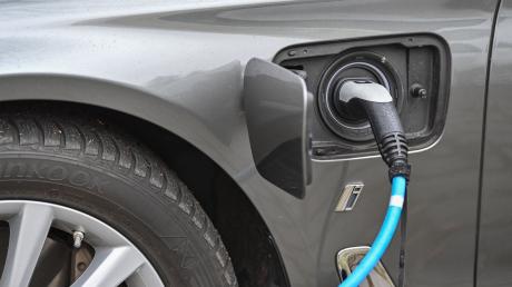 Ein Elektrofahrzeug der Marke BMW wird an einer Ladesäule aufgeladen.