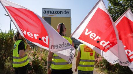 Streikende stehen mit Verdi-Flaggen vor einem Verteilzentrum des Online-Händlers Amazon in Leipzig (Archivbild).