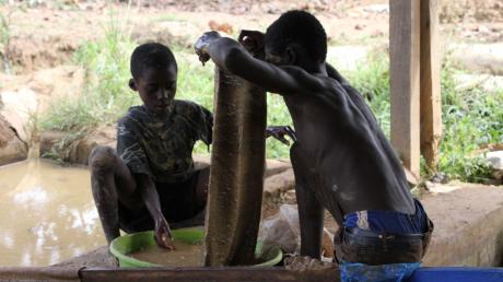 Goldverarbeitungsanlage in der Region Brong-Ahafo in Ghana: Zwei kleine Jungen waschen das Erz, um es vom Schlamm zu trennen.