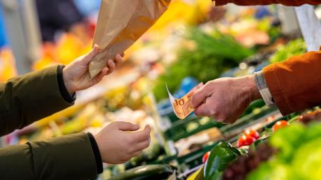 An einem Marktstand wird mit Bargeld eingekauft: Nahrungsmittel verteuerten sich um 3,8 Prozent.