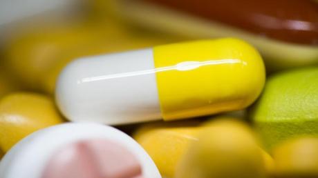Tabletten, Kapseln und Pillen in verschiedenen Farben liegen in einem Medikamenten-Behälter einer Apotheke. Wann kommt die Pille gegen Corona?