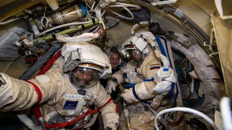 Die russischen Kosmonauten Anton Schkaplerow (l) und Pjotr Dubrow (r) bereiten sich mit Unterstützung von NASA-Astronaut Mark Vande Hei (hinten)  auf einen Weltraumspaziergang vor.